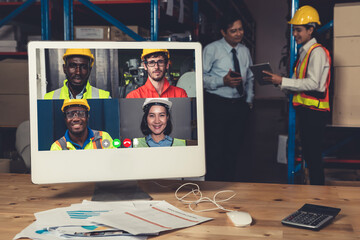 Warehouse staff talking on video call at computer screen in storage warehouse . Online software technology connects people working in logistic factory by virtual conference call on internet network .