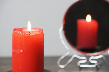 Concept photo of a lighted candle that is reflected in the mirror.Christmas divination and spirituality.Religion and divine.Psychology,motivation.Power of thought.Never give up,go for your goals.