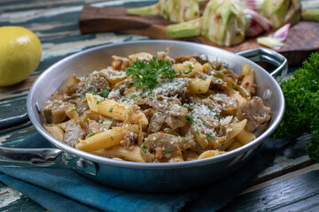 pasta con carciofi in padella di metallo