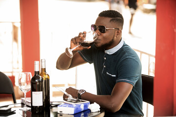 handsome young man drinking a glass of red wine