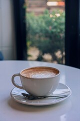 Beautiful coffee cup of latte next to the window