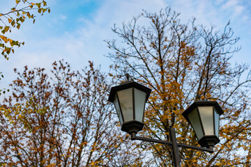 Simple street lights under the open sky. Black metal frame and dusty white glass with light bulbs