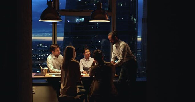 Successful businessteam engaged in group meeting in modern luxury boardroom office, work until late or gathered in early morning solve business, develop startup together. Seminar, brainstorm concept