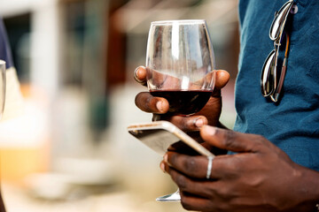 young man holding a glass of red wine
