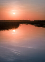 Scenic sunset landscape with water reflections and mood colors at autumn evening in Finland.