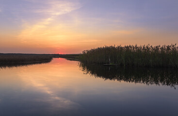 Fototapeta premium Scenic sunset landscape with water reflections and mood colors at autumn evening in Finland.