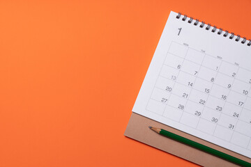 close up of calendar on the orange table background, planning for business meeting or travel planning new year concept