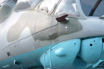 Helicopter cabin fragment close up. Camouflage aircraft fuselage and bulletproof glass