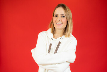 Portrait of a pretty young woman in white sweater hugging herself. Concept of selfish emotion.