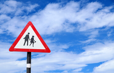 School Warning Sign with the sky background, School zone or children crossing sign isolated on cloudy sky background