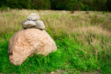 three small stones on a rock in meadow