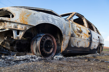 Burned down car, abstract background, selective focus. The situation of protests in the world.