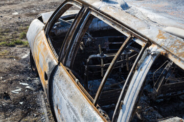Burned down car, abstract background, selective focus. The situation of protests in the world.