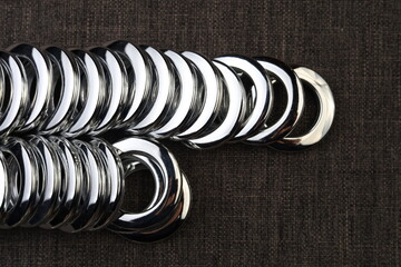 Glossy nickel-plated or chrome-plated Eyelets for attaching curtains in the design workshop.