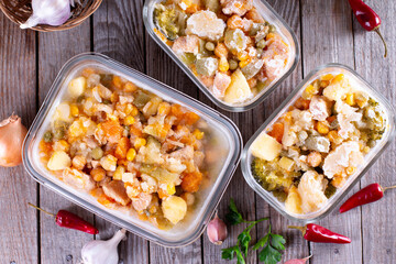 Frozen vegetables and meat (stew) in containers on a table. Top view