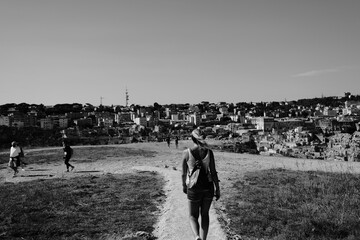 a group of people walking on a path with a city in the background