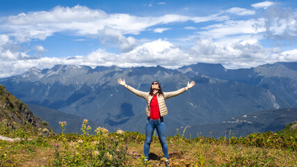 Embrace the world around, young woman in the mountains,