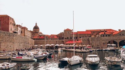 Old City Harbor of Dubrovnik with boats. Boats docked at Dubrovnik old city port with Dubrovnik Cathedral in the background