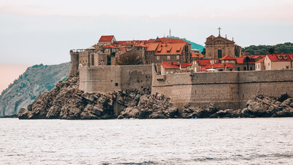 View of Dubrovnik Old Port from Lokrum. Dubrovnik old city harbor view with city walls and red rooftops from boat coming from Lokrum