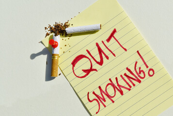 Quit smoking new year resolution concept with broken cigarette and sticky note