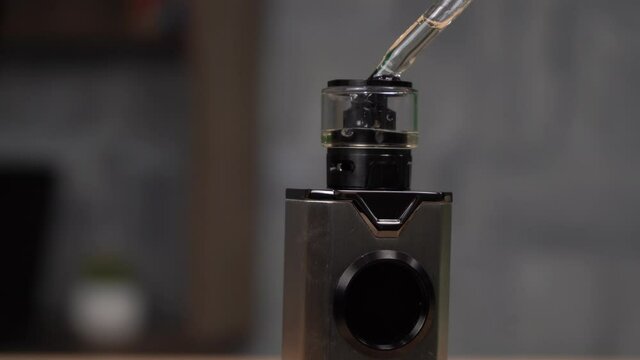a person fills his vape with a special liquid