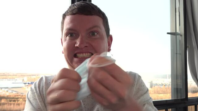 the young man takes off his medical mask and breaks it half. angry evil wicked
