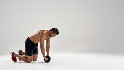 Young caucasian bodybuilder working with ab roller