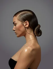 Fotobehang Kapsalon Beautiful young woman with natural make-up and smooth hairstyle gathered in a bunch close-up in profile. Emotions.  © EkaterinaJurkova