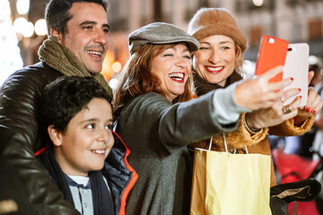 Happy family taking selfie at the local Christmas Market outdoors. .
