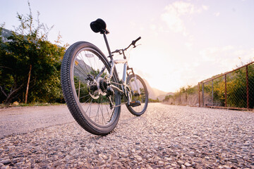 Fototapeta na wymiar Healthy lifestyle. Close up of mountain bicycle on the road against sunny sky.