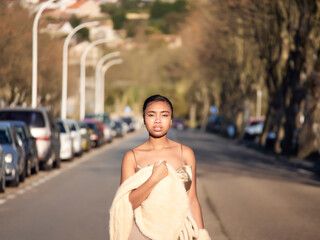 Black girl looking smart on the street, wearing a party dress