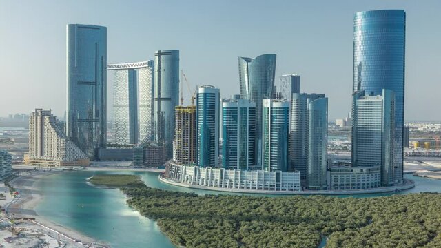Buildings on Al Reem island in Abu Dhabi timelapse from above. Aerial citiscape of Al Reem Island at morning, showing the reflection on skyscrapers.