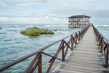 Beautiful landscape. Day on seashore. Wooden bridge on Cloud 9 beach, Siargao Island Philippines.
