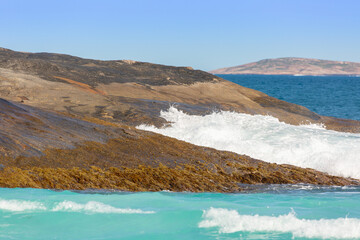 Fototapeta na wymiar Oncoming waves at the Shore of the Hellfire Bay in the Cape Le Grand Nationalpark close to Esperane in Western Australia