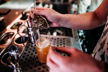 bartender pouring cocktail in bar