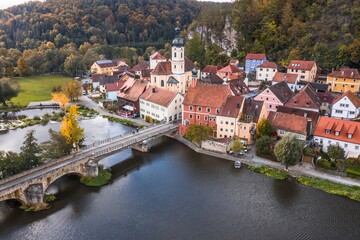 Fototapeta na wymiar Bild einer Luftaufnahme mit einer Drohne der Stadtansicht des Markt Kallmünz Kallmuenz in Bayern und der Brücke über den Fluss Naab und Vils und der Burg Ruine auf dem Berg, Deutschland