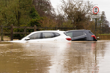 Broken down cars submerged in a flooded ford after heavy rain. December 2020. Much Hadham,...