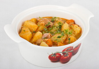 Home-made roast beef with potatoes. Serving in a white saucepan