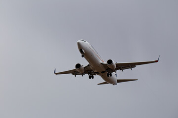 Airliner coming in to land under heavy rain clouds. (Anonymised, distinguishing mark removed).