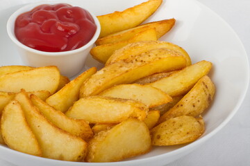 Fried potato slices with ketchup