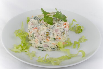 A portion of Russian Olivier salad on a white plate