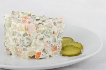 A portion of Russian Olivier salad on a white plate