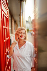 Outdoor portrait of happy young woman walking by city street.