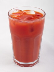 Tomato juice with ice cubes in a glass Cup