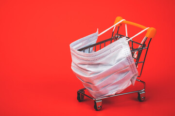Supermarket cart with protective mask on - shopping during Coronavirus COVID-19 epidemy concept