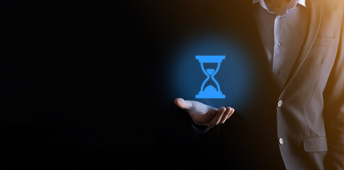 Businessman man holds in hand hourglasses icon. Time expires. A reminder to action. Business concept. Elements for design.