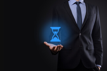 Businessman man holds in hand hourglasses icon. Time expires. A reminder to action. Business concept. Elements for design.