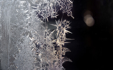 Close-up of a frost pattern on window glass formed winter morning