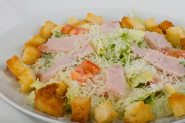 Caesar salad with Turkey on a white plate