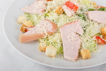 Caesar salad with Turkey on a white plate